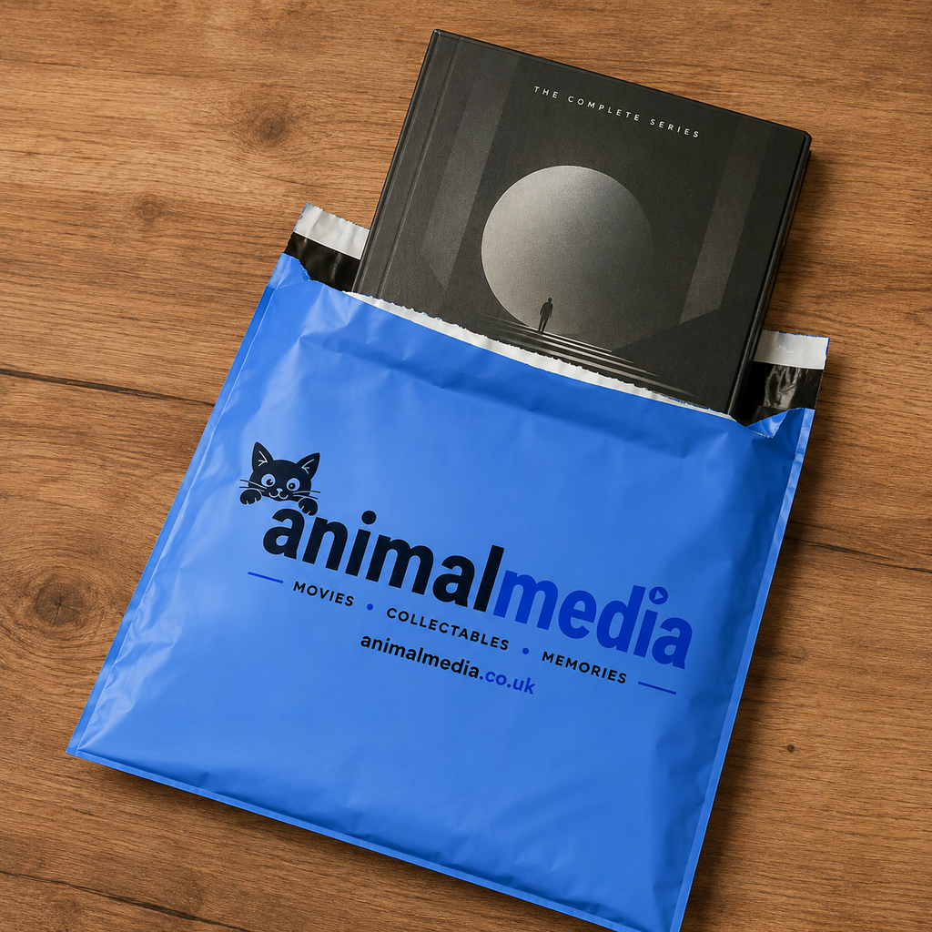 A blue Animal Media shipping mailer envelope with the brand logo printed on it, holding a boxed collectible series, placed on a wooden tabletop.