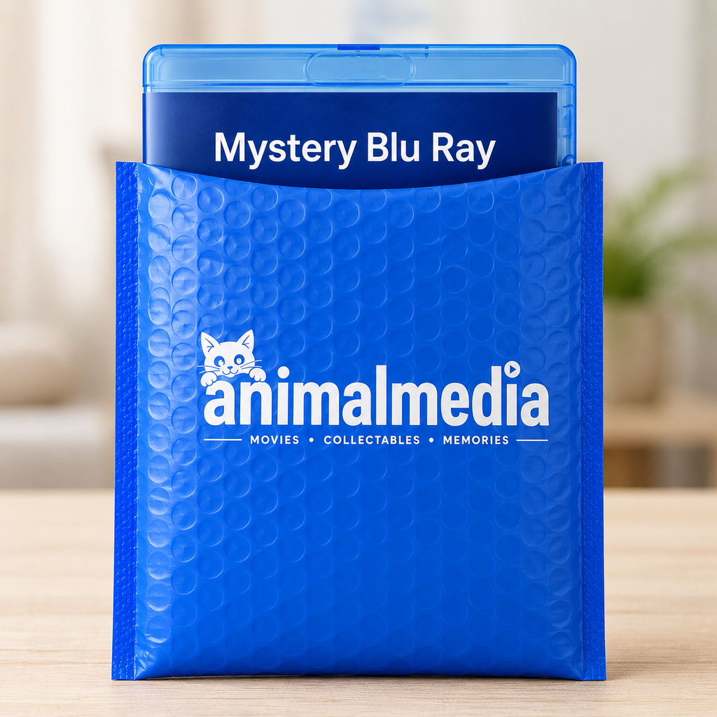 A blue bubble mailer envelope with the white 'animalmedia' logo on the front, holding a blue Blu-ray case labeled 'Mystery Blu Ray,' set on a light wood surface with a softly blurred indoor background.