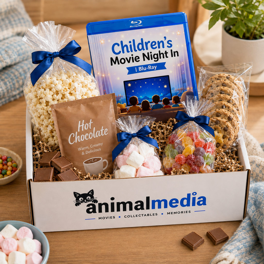 A curated gift box from Animal Media titled 'Children's Movie Night In' filled with snacks and treats on a wooden table. The box includes a Blu-ray movie case, a bag of popcorn tied with a blue ribbon, a packet of hot chocolate, marshmallows, gummy candies, cookies, and chocolate squares.